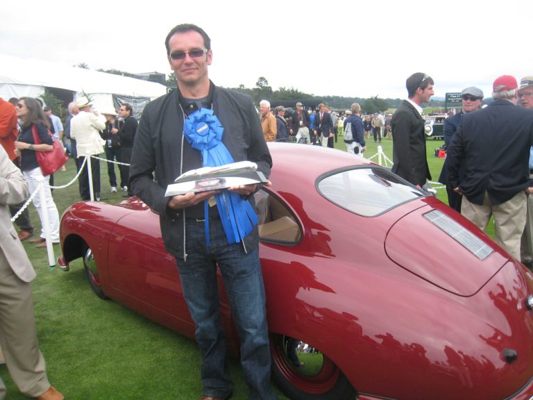 Jean-Noel holds winning trophy for Porsche Gmund win at Pebble Beach Concours d'Elegance.